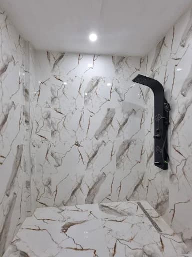 Douche à l'italienne avec paroi noire et carrelage marbre